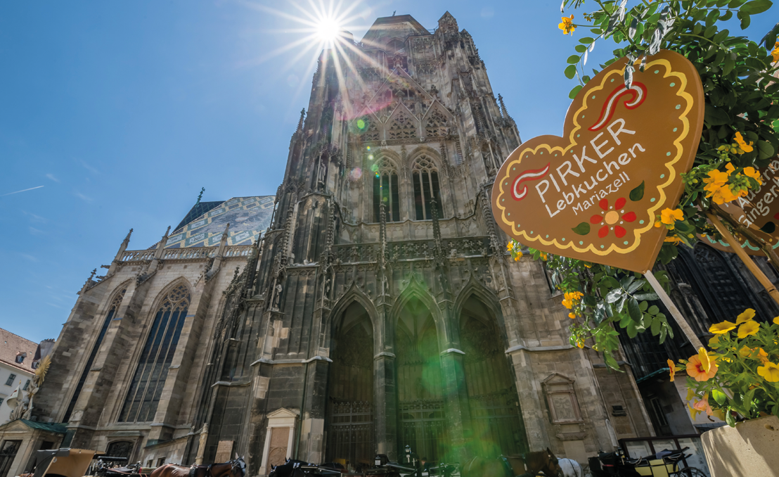 Wien Stephansdom mit Sonnenstern; vorn Pirker Lebkuchen Herzschild und gelbe Blumen.