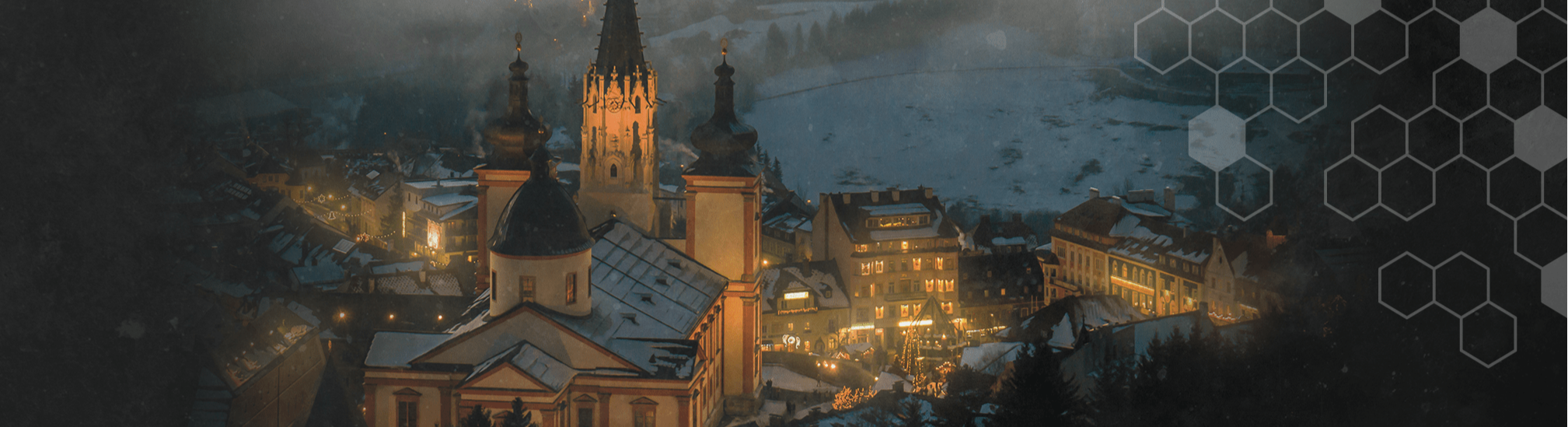 Mariazell bei Nacht: beleuchtete Basilika und Altstadt im Schnee – stimmungsvolles Winterpanorama.