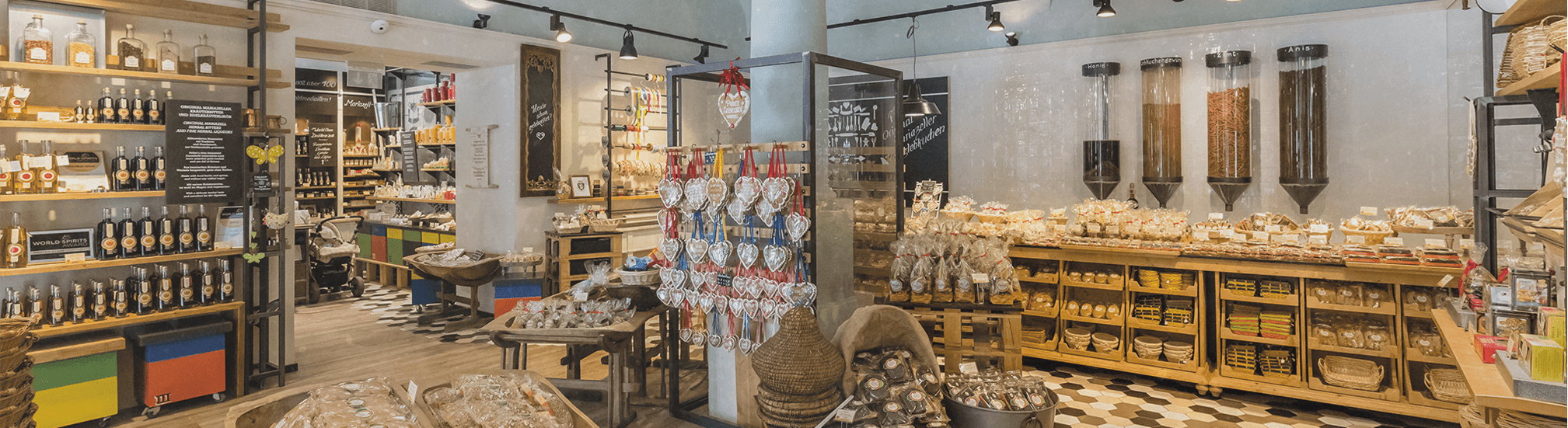 Pirker Lebkuchen Shop innen: Holzregale, Herzlebkuchen-Display und Zutaten-Schüttsäulen.