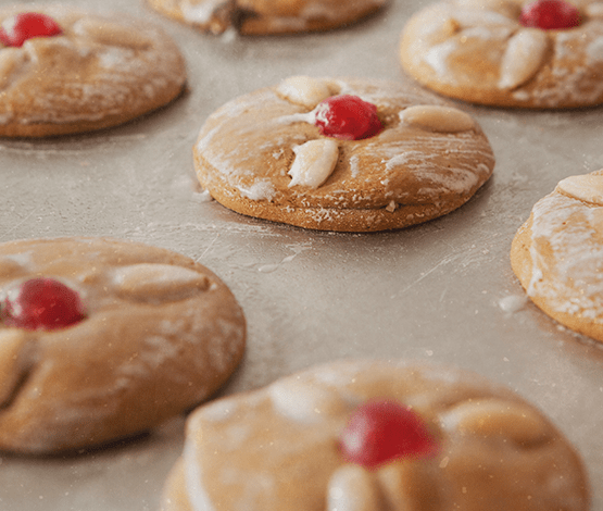 Mandellebkuchen mit roter Kirsche auf Backblech – klassische Pirker Spezialität.