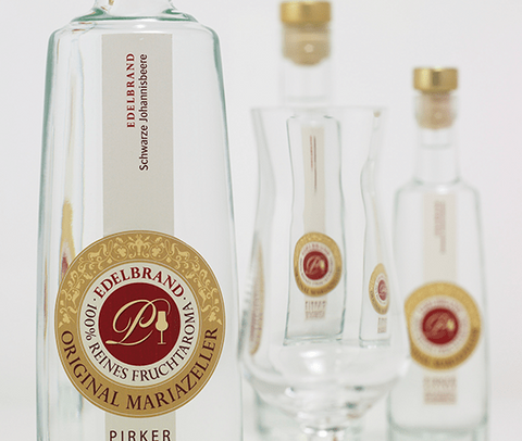 Original Mariazeller Edelbrand: Flasche mit Siegel und Verkostungsglas, Produktfoto.